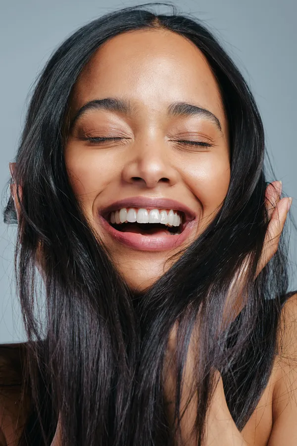 PRP-for-Hair-Loss-Treatment A beautiful latin woman smiles and runs her fingers through her long, beautiful hair, happy with her PRP for hair loss and restoration treatment from Healthy Aging Medical Centers of New Jersey in Northern New Jersey.