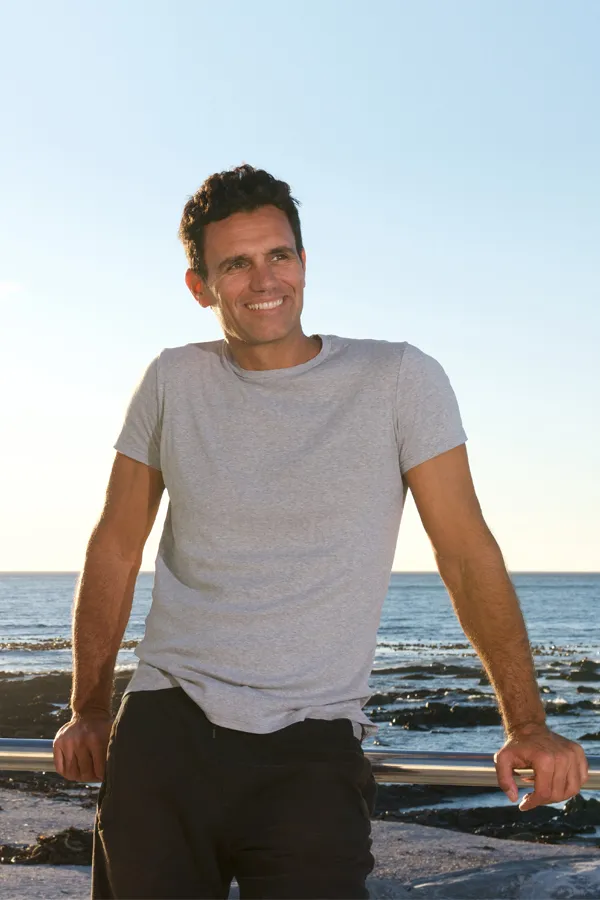 Radiofrequency-Microneedling-for-Stomach-Treatment A trim man stands by the beach. Get Radiofrequency Microneedling for Stomach Skin Treatment from Healthy Aging Medical Centers of New Jersey in Northern New Jersey.